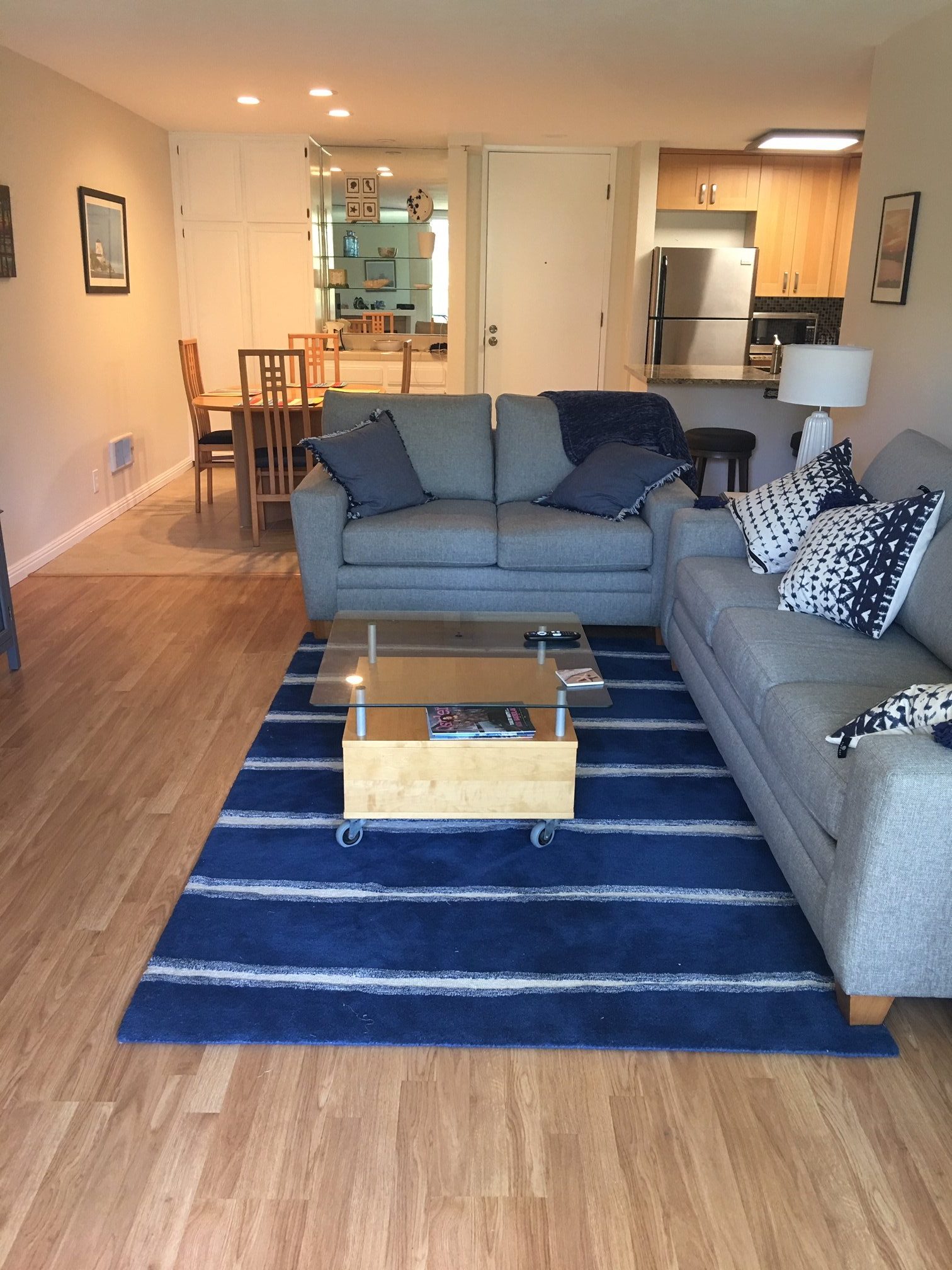 Unit F-106 blue area rug and grey sleeper sofa and love seat